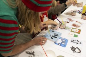 An elf (dressed up) doing Christmas crafts