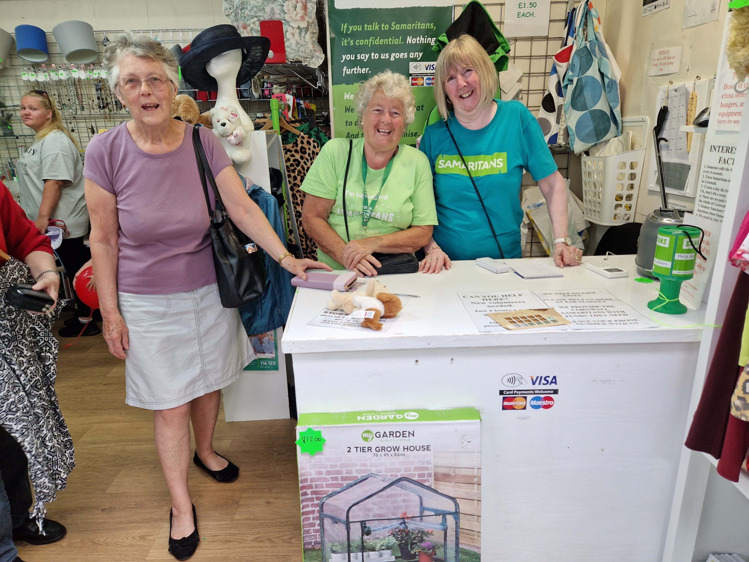 Staff and a customer at the Samaritans Shop in Par Market