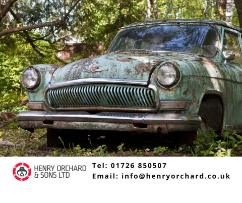 A vintage, pale blue car, rusting and in sate of poor repair in some trees. Beneath is the logo for Henry Orchard and Sons, the email info@henryorchard.co.uk and the phone number 01726 850507